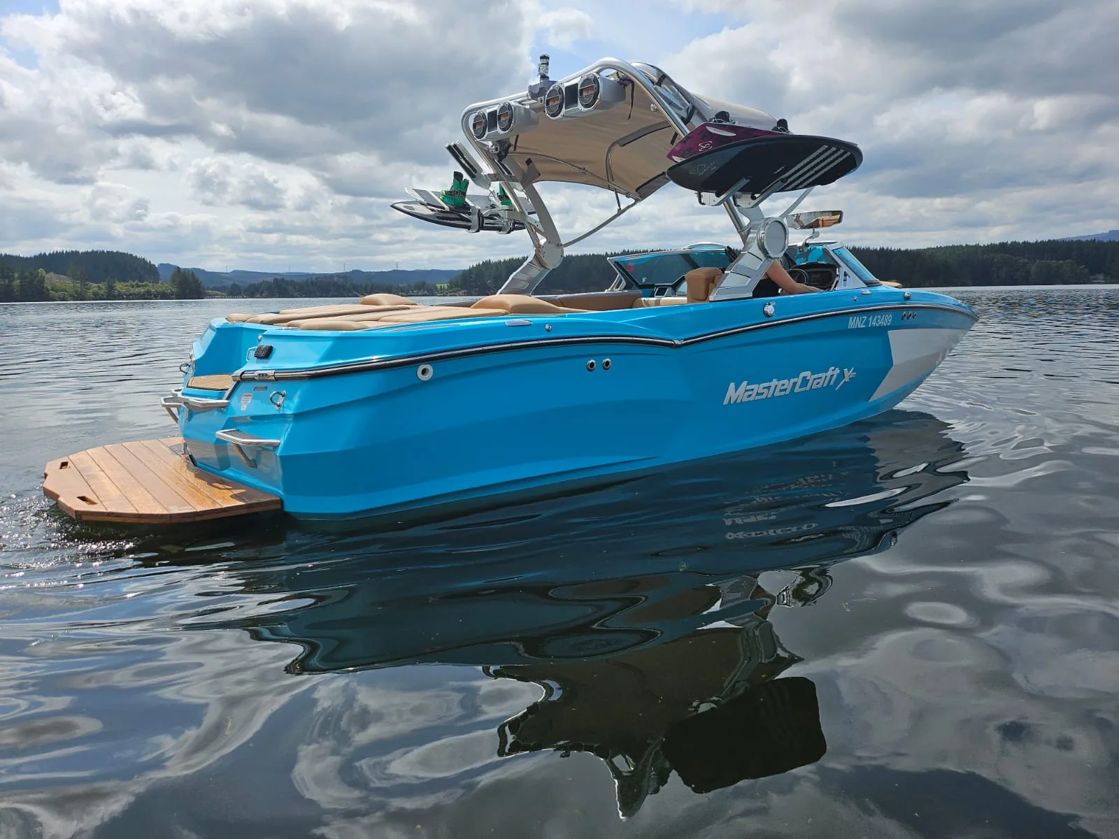 Blue MasterCraft XStar on calm Lake Maraetai water