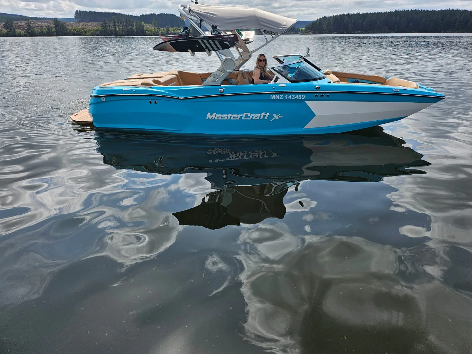 MasterCraft boat reflected in still lake water